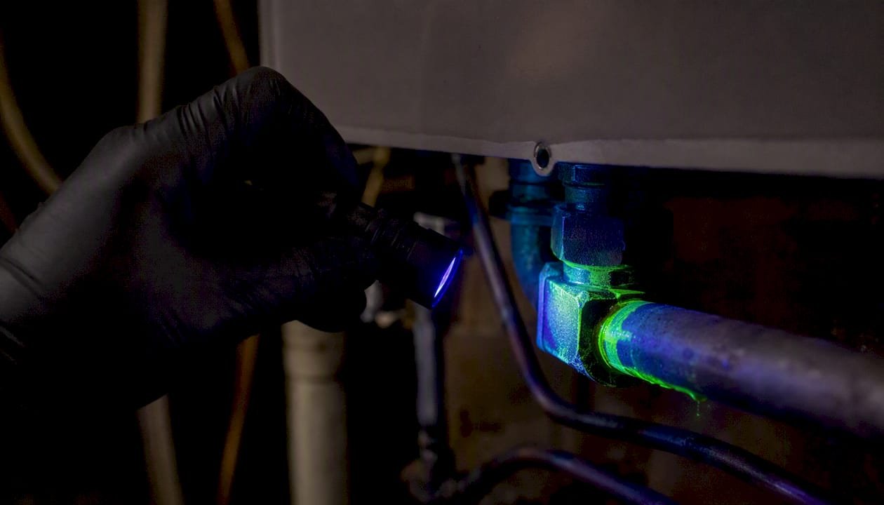 UV light showing fluorescent dye leak on HVAC pipe