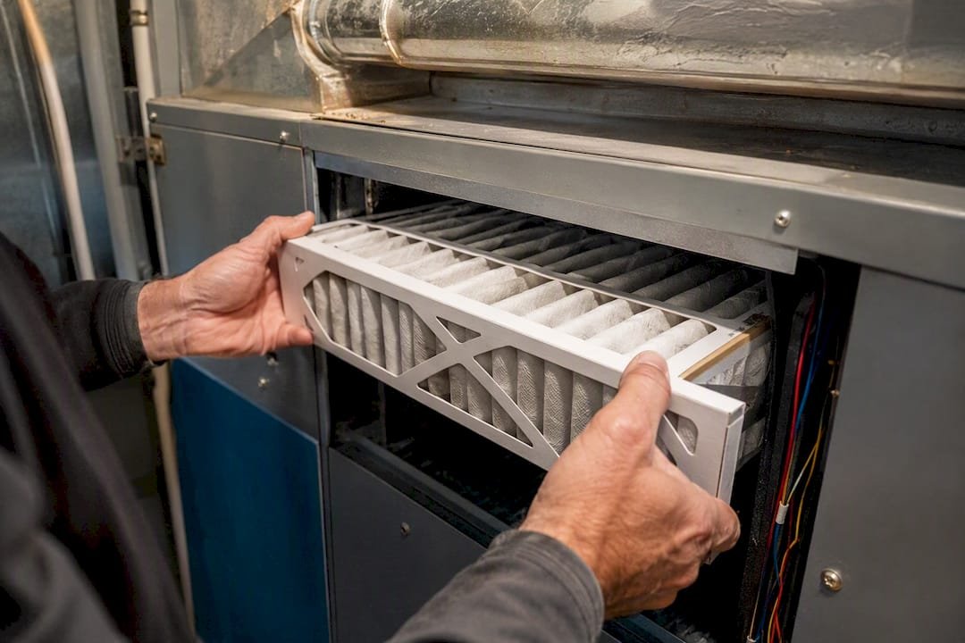 Technician installing air filter in commercial HVAC unit