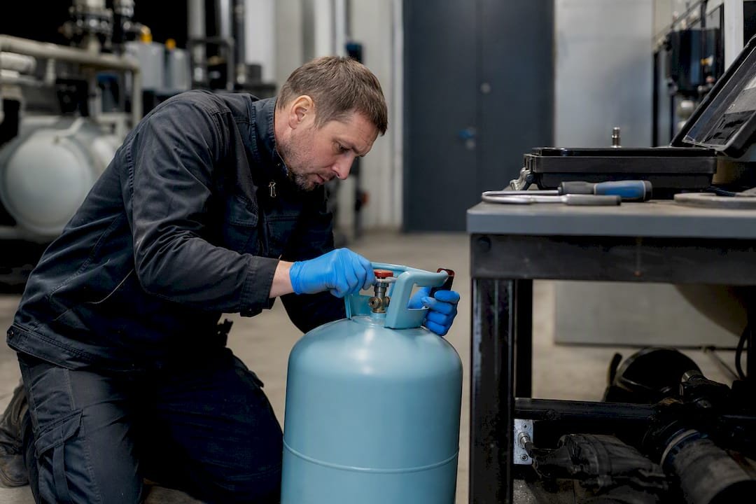 Technician weighing refrigerant cylinder