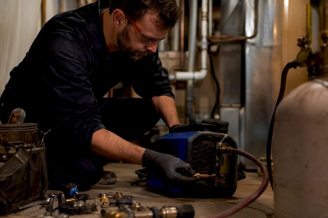 Technician connecting recovery machine to refrigerant cylinder